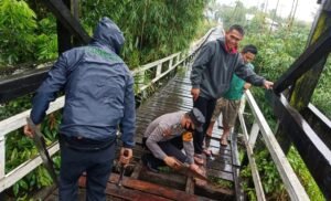 Polsek Kota Baru Perbaiki Lantai Jembatan Gantung