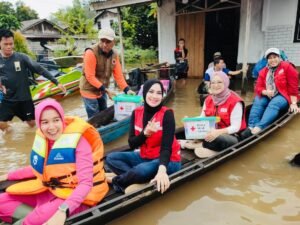 Gunakan Sampan, Ketua PMI Melawi Beserta PC Bhayangkari Salurkan Bantuan Sembako dan Cek Kesehatan Bagi Korban Bencana Banjir