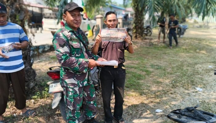 Babinsa Koramil 1205-13/Ella Hilir Bagikan Leaflet, Imbau Warga Tak Bakar Lahan dan Gunakan Masker
