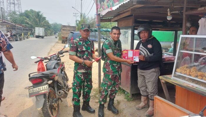 Cegah Karhutla, Babinsa Koramil 16/Belimbing Bagikan Leaflet kepada Warga di Pasar Simpang Batu Buil